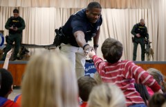 Staff photo by C.B. Schmelter / Loftis Middle's School Resource Officer Mike Houston hands a badge to Ryan Stone after he answered a question during a safety program for the kindergarteners at McConnell Elementary School on Thursday, Feb. 1, 2018. On Thursday, the Hamilton County school board approved a resolution asking the Tennessee General Assembly to allow school districts to receive state funding to hire school security officers in situations where local law enforcement agencies are unable to provide an SRO.