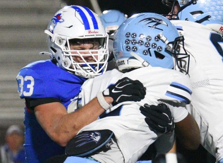 Staff photo by Matt Hamilton / Hardin Valley's Nicolas Rivers hangs onto the ball as Cleveland's Daxton Evans hits him at the line of scrimmage during the Blue Raiders' win Friday at Cleveland.