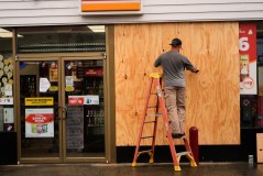 Jason Coffey boards up a convenience store at a gas station as Hurricane Isaias approaches Pensacola Beach, Fla., Friday, Oct. 9, 2026. (AP Photo/Gerald Herbert)