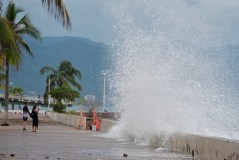 Tourists take photos of a water splashing against the wall as Hurricane Simon approaches Puerto Vallarta, Mexico, Sunday, Oct. 11, 2026. (AP Photo/Fernando Llano)