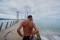 A man stands at the entrance to a pier closed off with caution tape after the passing of Hurricane Simon in Puerto Vallarta, Mexico, Monday, Oct. 12, 2026. (AP Photo/Fernando Llano)
