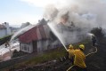 Firefighters work to douse a fire on house in flames during the Norte Fire on Friday, Oct. 16, 2026, in San Juan Capistrano, Calif. (AP Photo/Jae C. Hong)